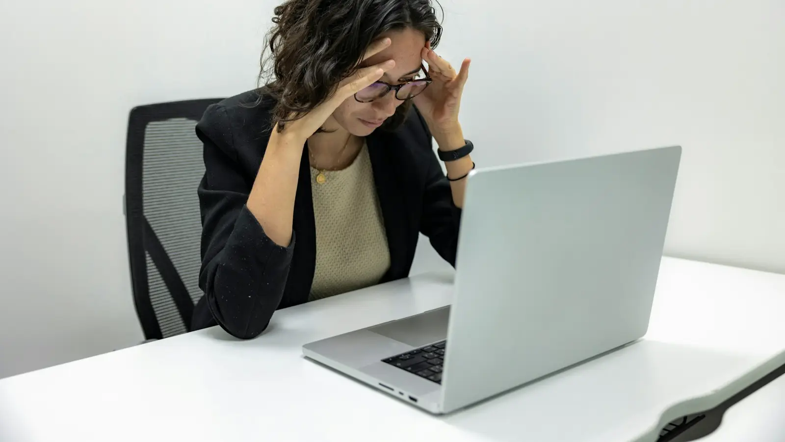 Mujer frustrada frente a su computadora portátil