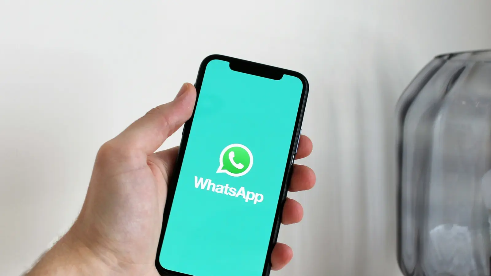 Mano sosteniendo un celular con WhatsApp abierto