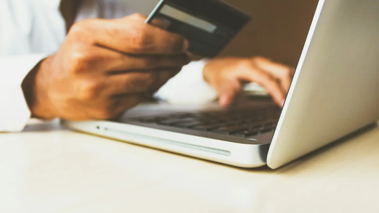 Persona pagando una compra online con tarjeta desde su computadora