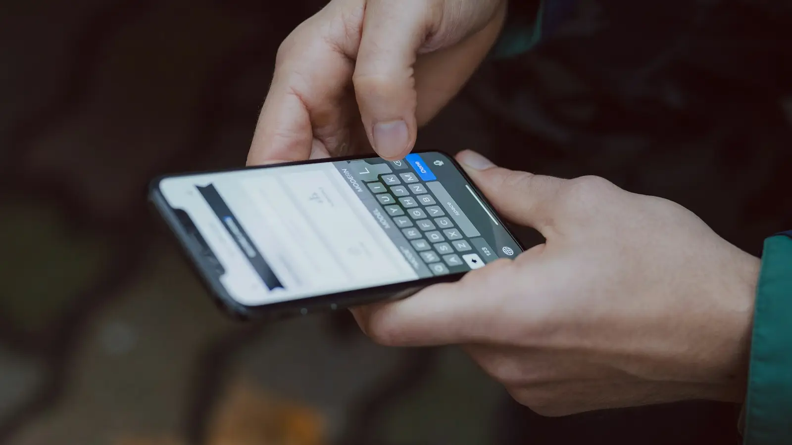 Manos escribiendo un mensaje en un celular