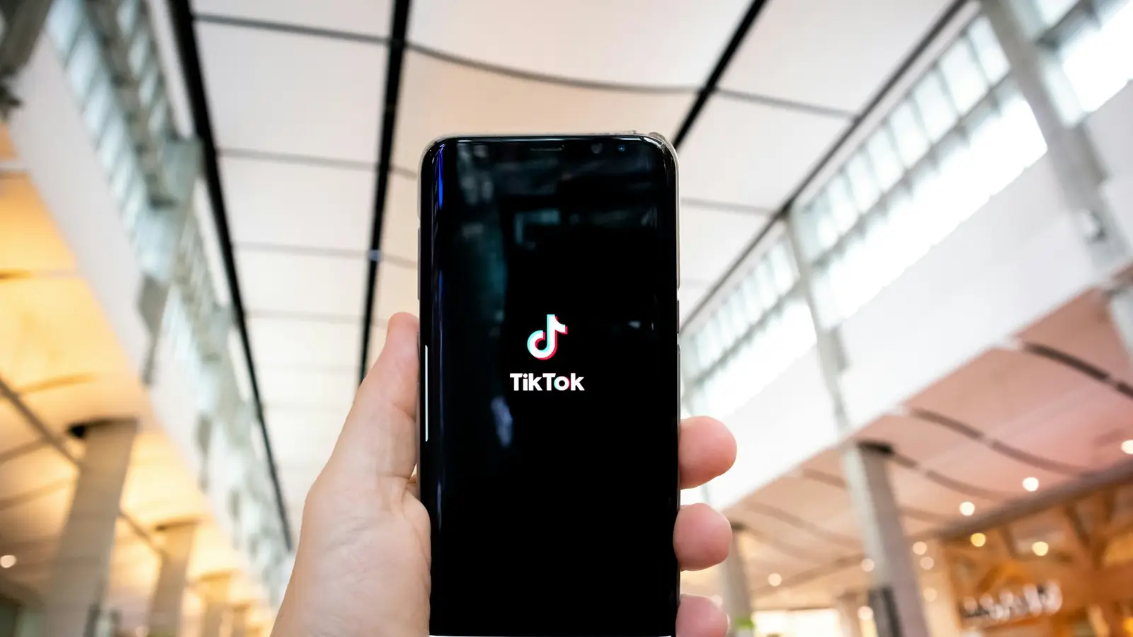 Mano sosteniendo un celular con TikTok abierto